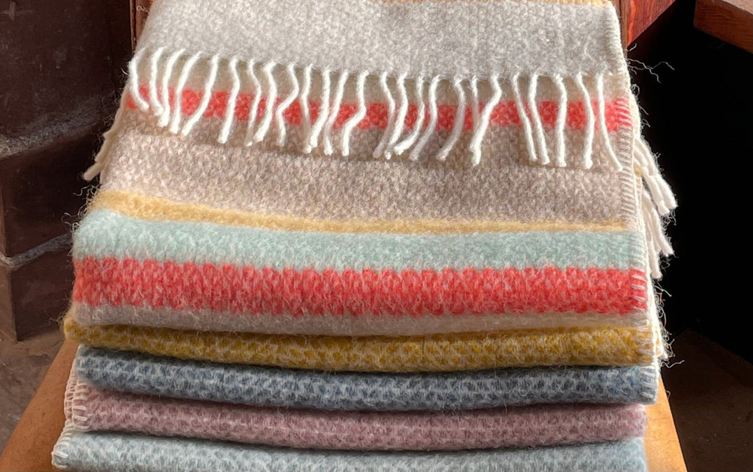 A colourful stack of pure new wool baby blankets.