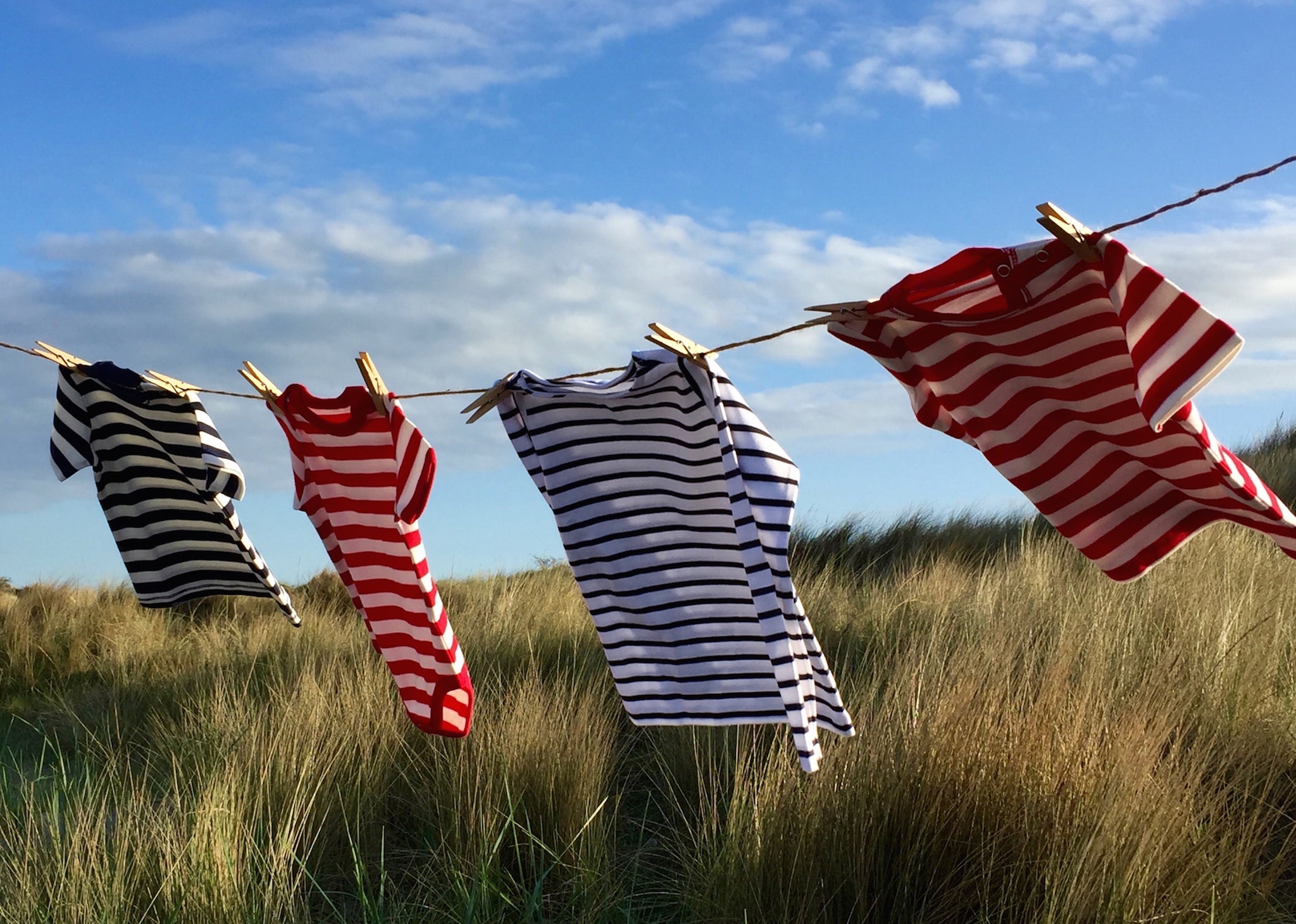 Organic cotton children's t-shirts in seaside stripes drying in the fresh air.