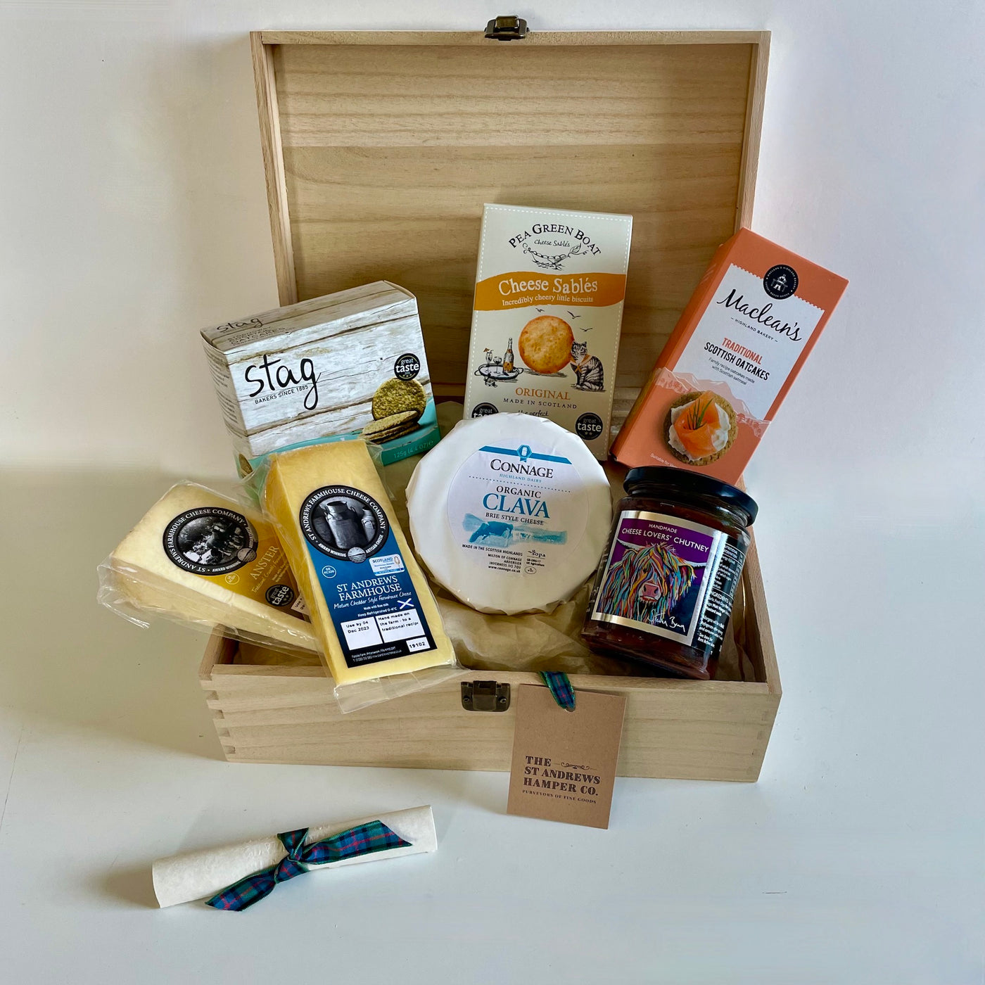 The St Andrews Hamper Company Cheese Lover's Tuck Box, featuring three cheeses, homestyle chutney plus oatcakes and cheesy nibbles. presented in a keepsake wooden box.