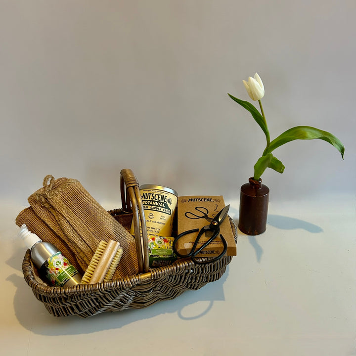 The St Andrews Hamper Company Gardener's Eco Basket featuring a handwoven, hessian lined oval basket filled with six useful goodies to help with gardening tasks.