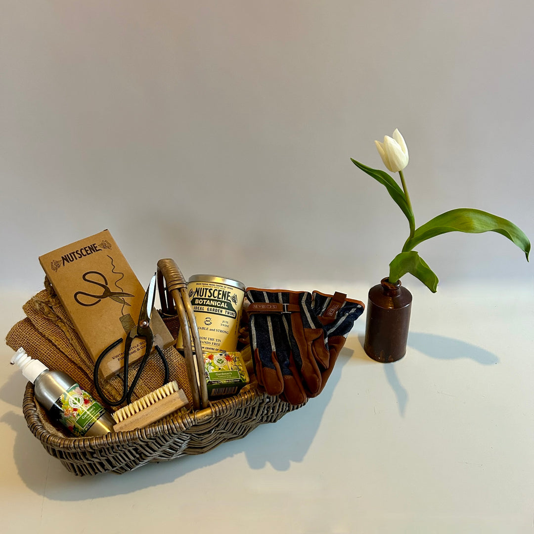 The St Andrews Hamper Company Gardener's Friends Gift Basket featuring a handwoven, hessian lined oval basket filled with six useful goodies to help with gardening tasks.