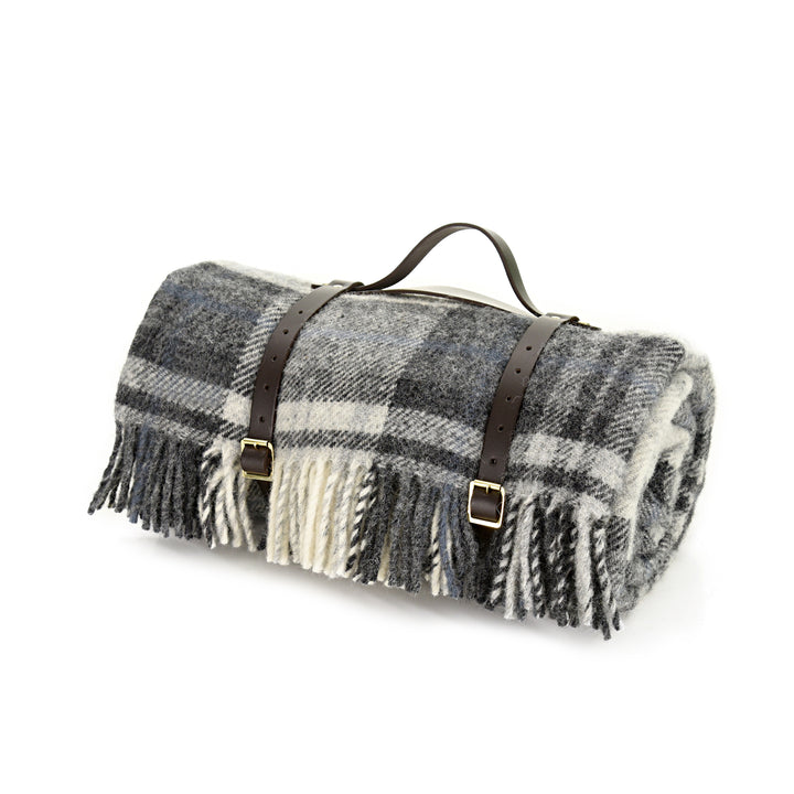 Pure new wool picnic blanket with waterproof backing in grey cottage tartan in shades black, grey and white of  with black leather carrier available from the St Andrews Hamper Company.