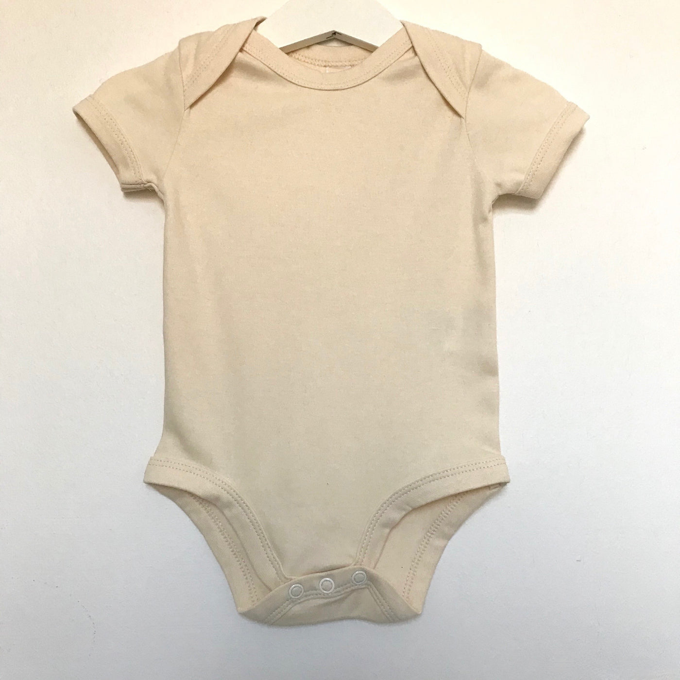 The St Andrews Hamper Company organic cotton baby bodysuit in natural, undyed, unbleached colour.