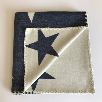 Rory & Ruby reversible star design throw in navy and ivory with traditional blanket stitch edging.