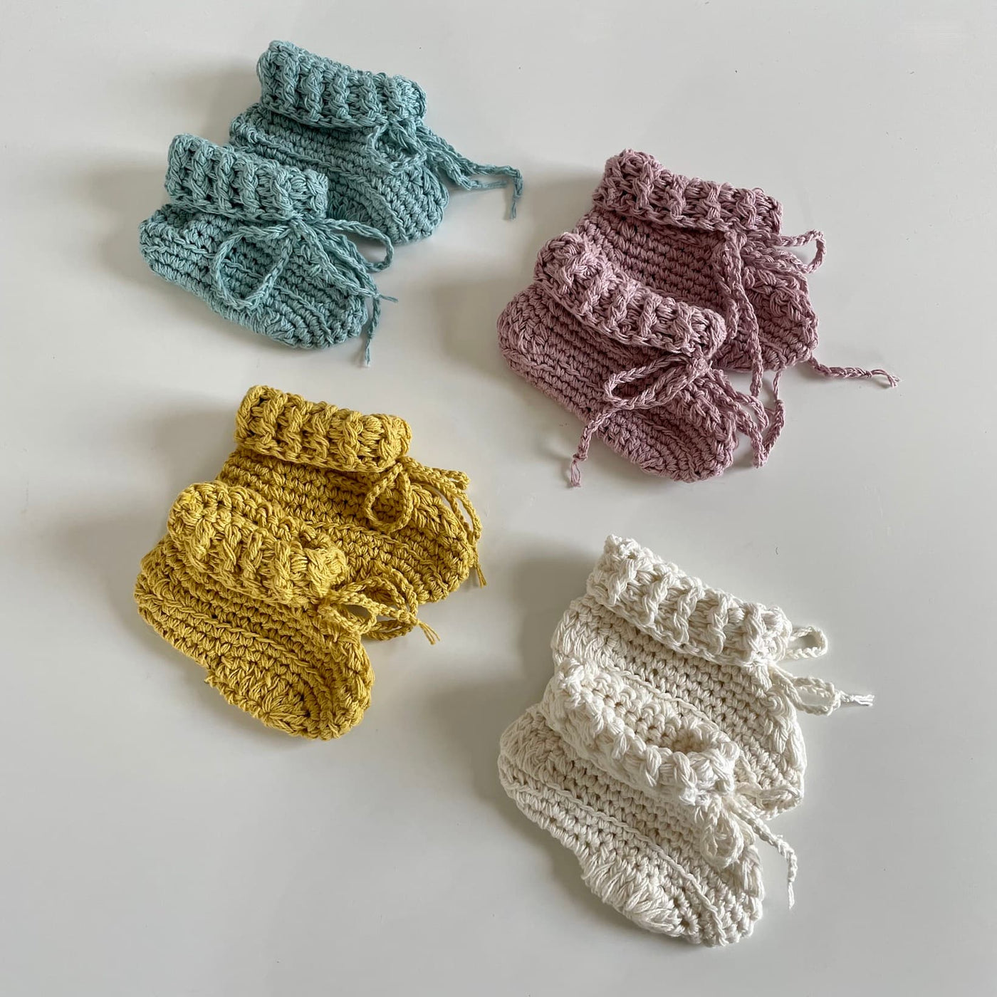 Hand crocheted organic cotton baby booties in four colourways.