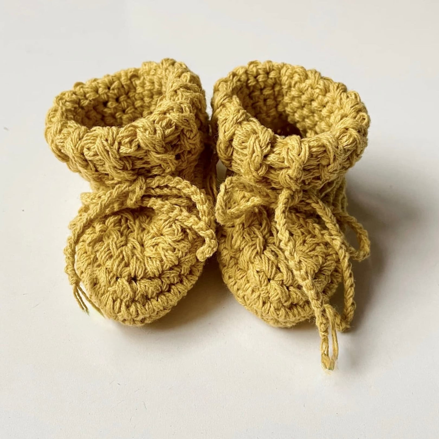 Hand crocheted organic cotton baby botties in sunshine gold.
