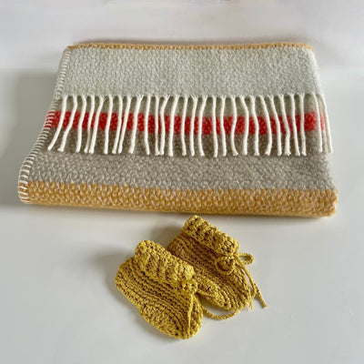 Pure new wool baby pram blanket in coastal stripes and cream tassels with hand crocheted organic cotton booties in sunshine gold. 
