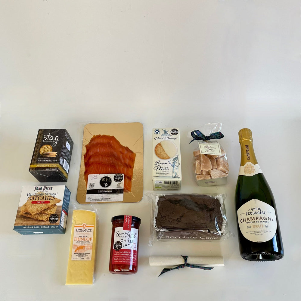 Unique graduation gift hamper with nine sweet and savoury treats including a bottle of champagne, carefully sourced from tried and trusted artisan suppliers based around Scotland, presented in our exclusive St Andrews Hamper Company canvas tote.